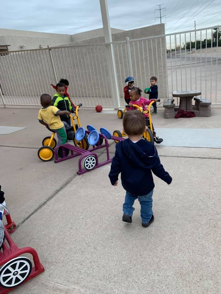 Children playing with riding toys outdoors