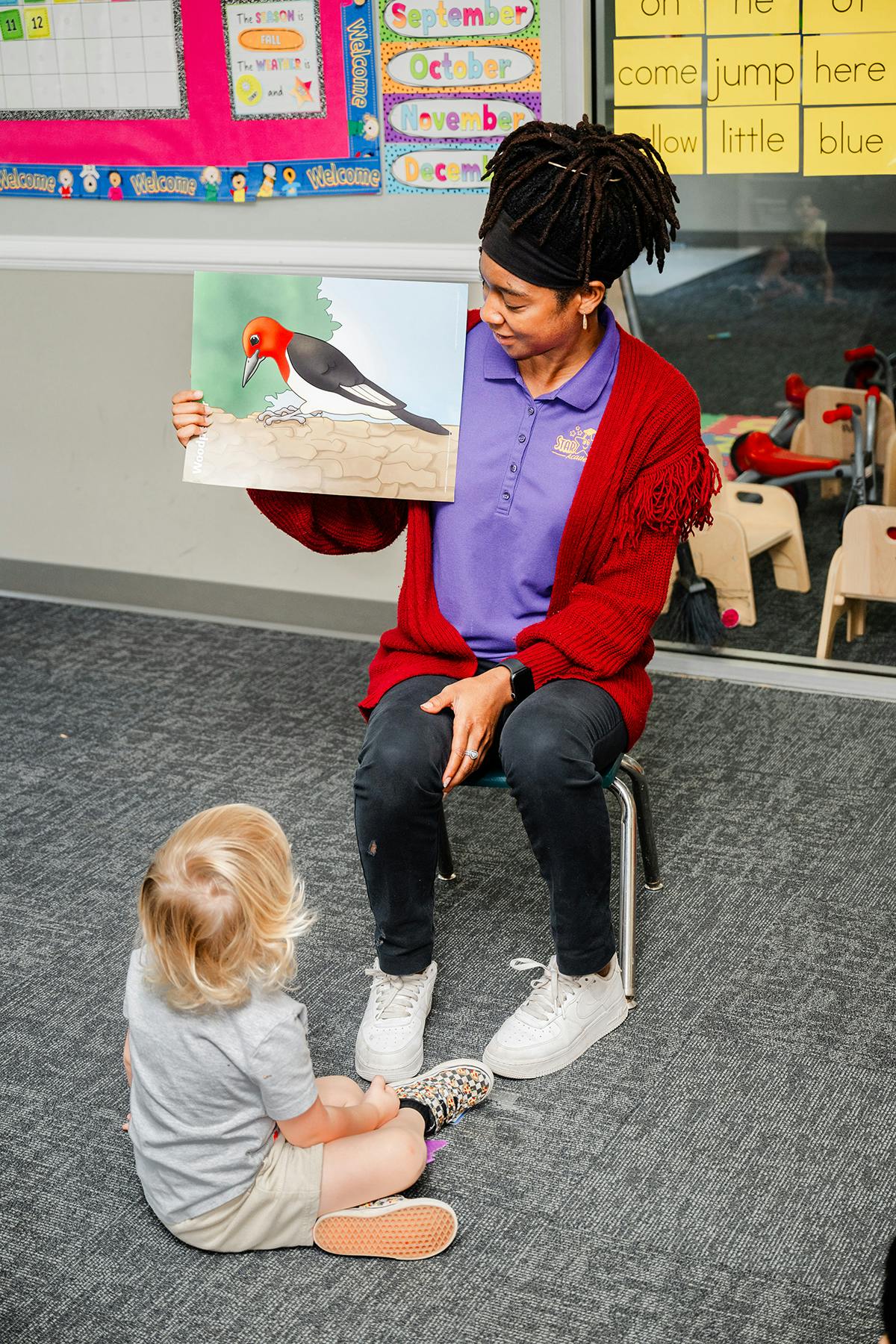 Person showing a child a picture of a bird