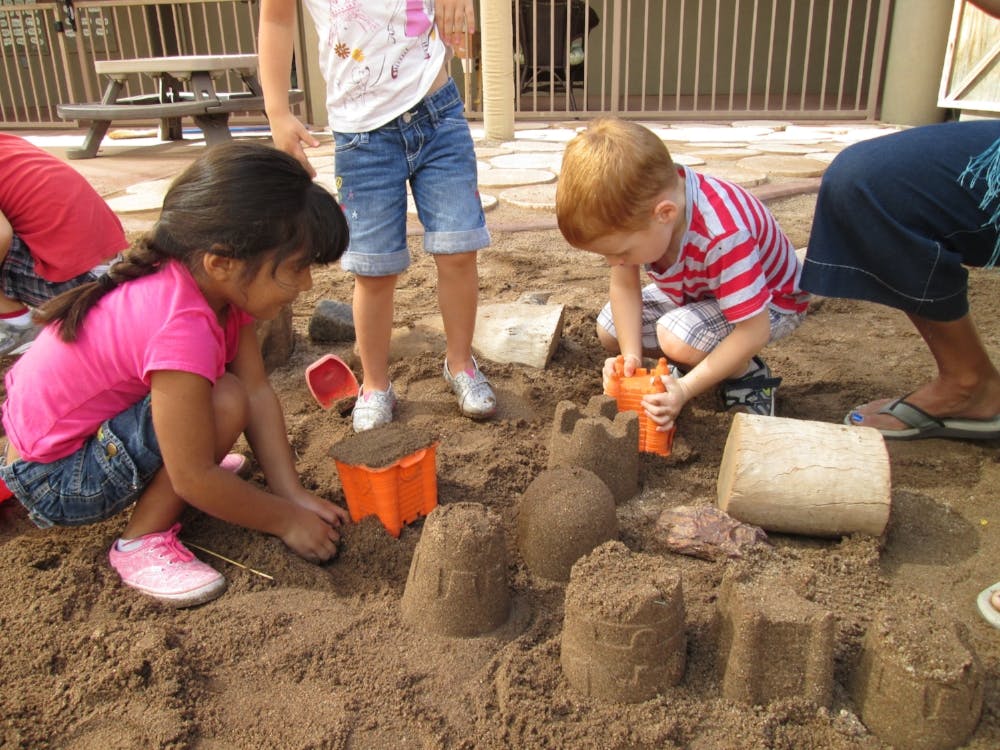 Children playing in sand, building sandcastles