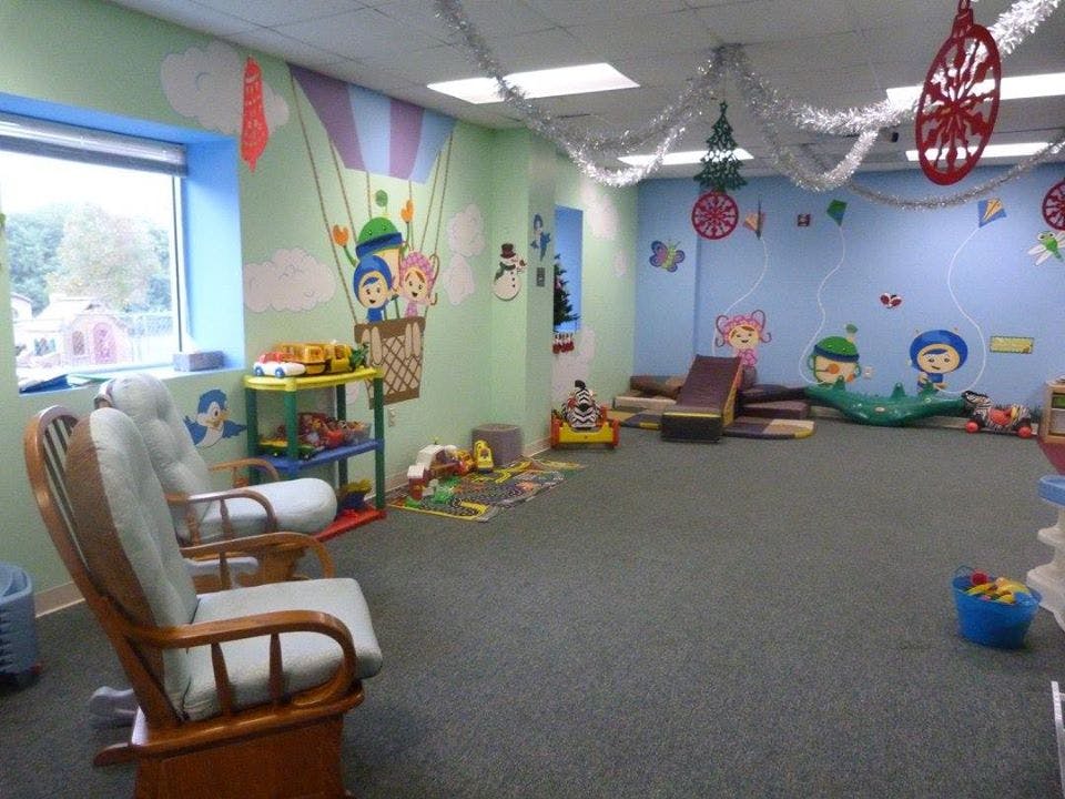 Playroom with colorful wall murals, toys, and two rocking chairs