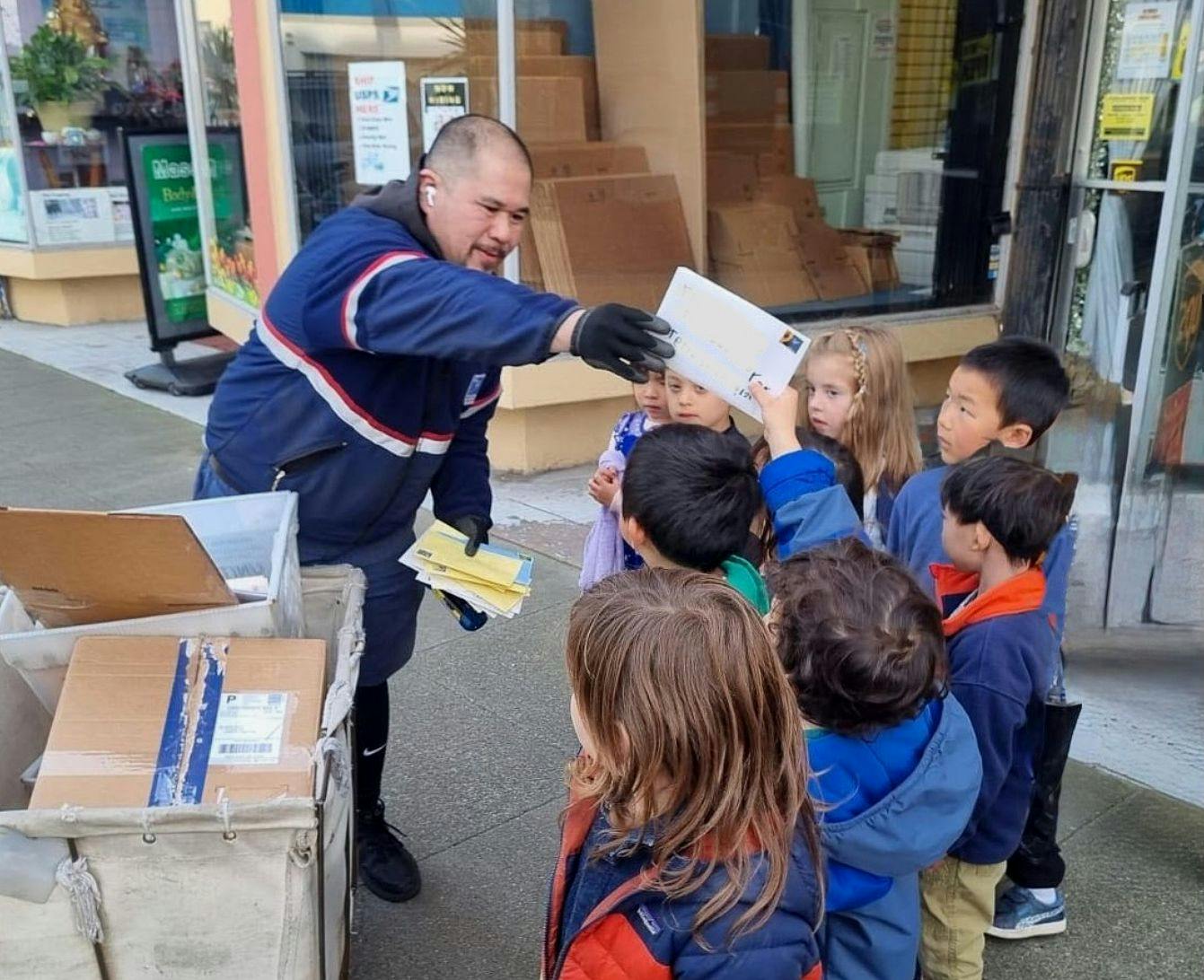 Person in uniform showing mail to a group of children