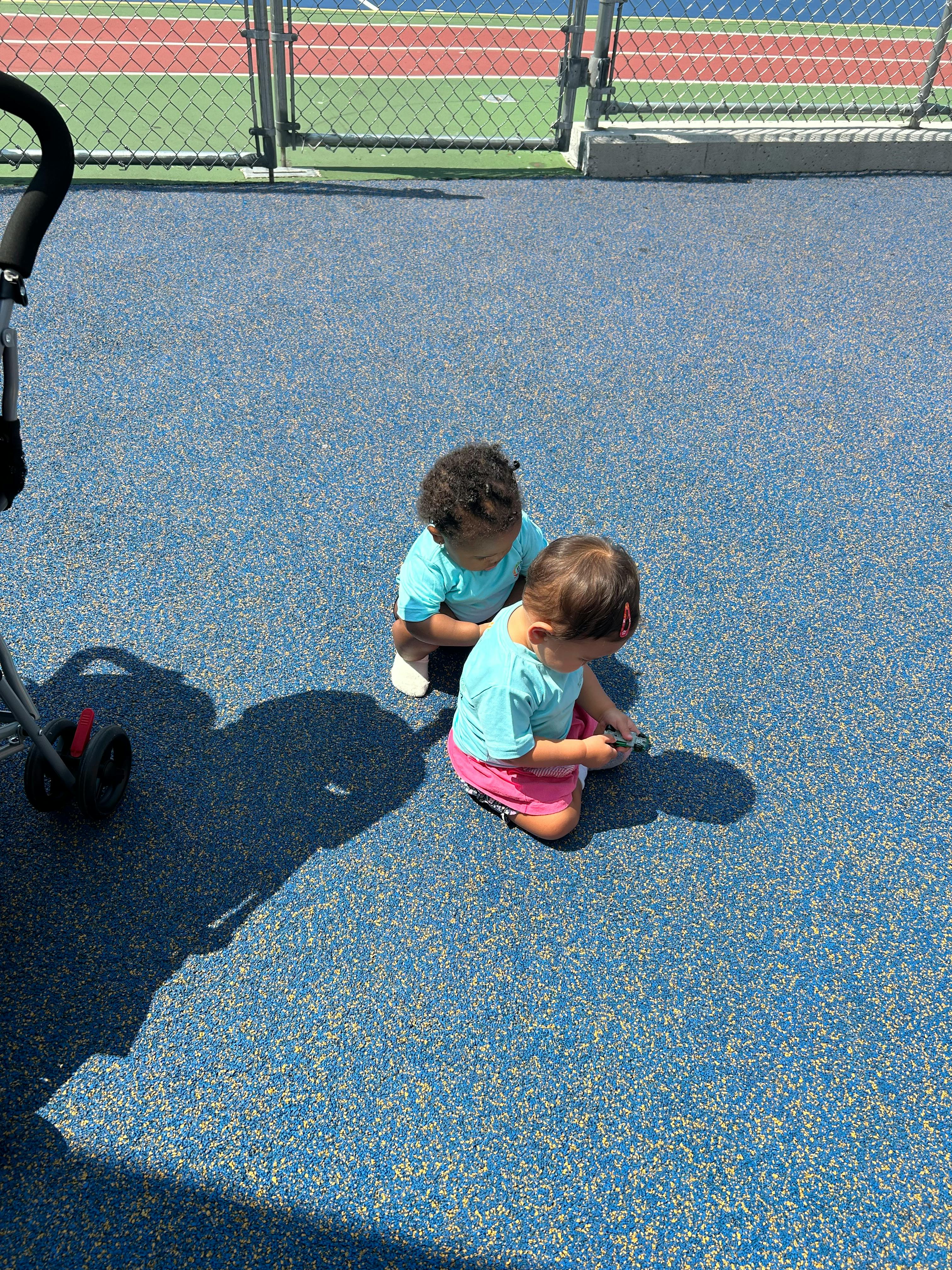 Two children kneeling on a blue surface