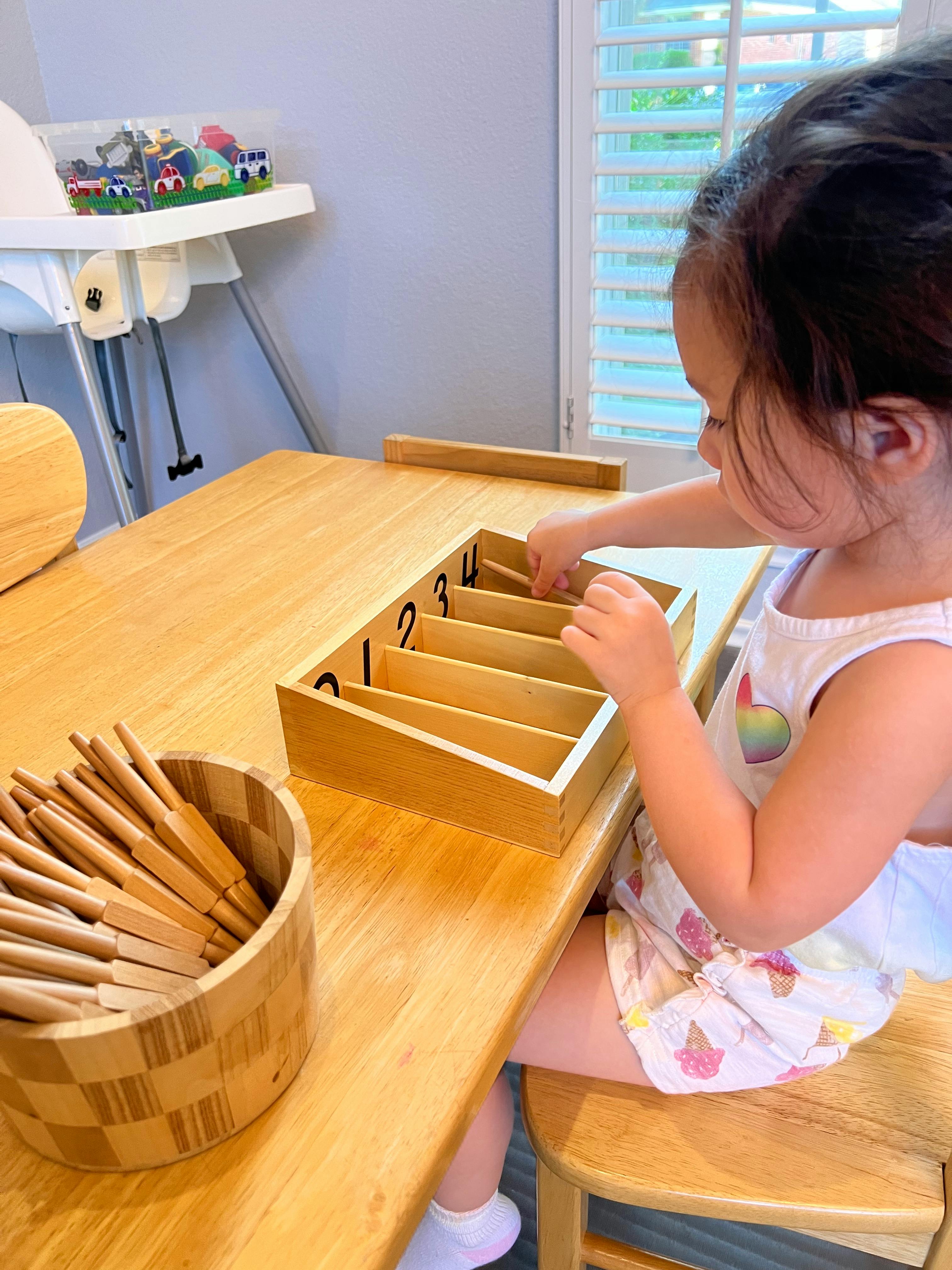 Child playing with a wooden sorting box with numbers 1, 2, 3, 4
