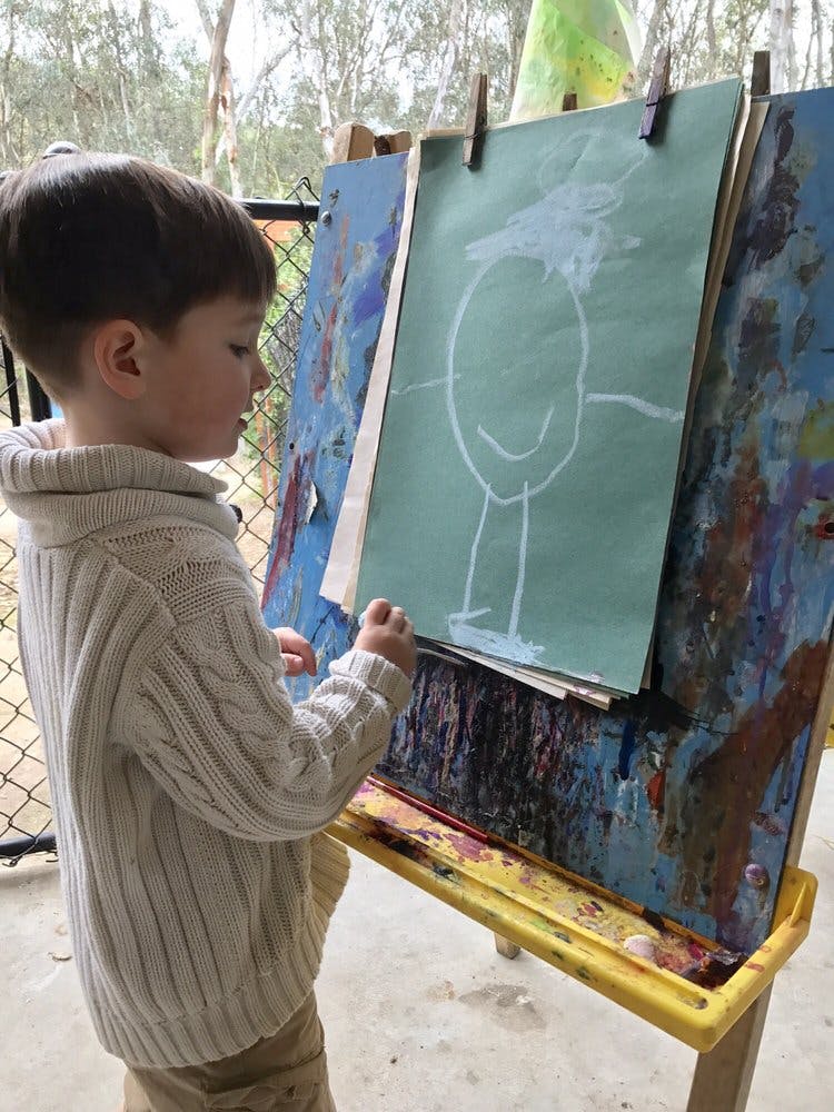 Child drawing on an easel