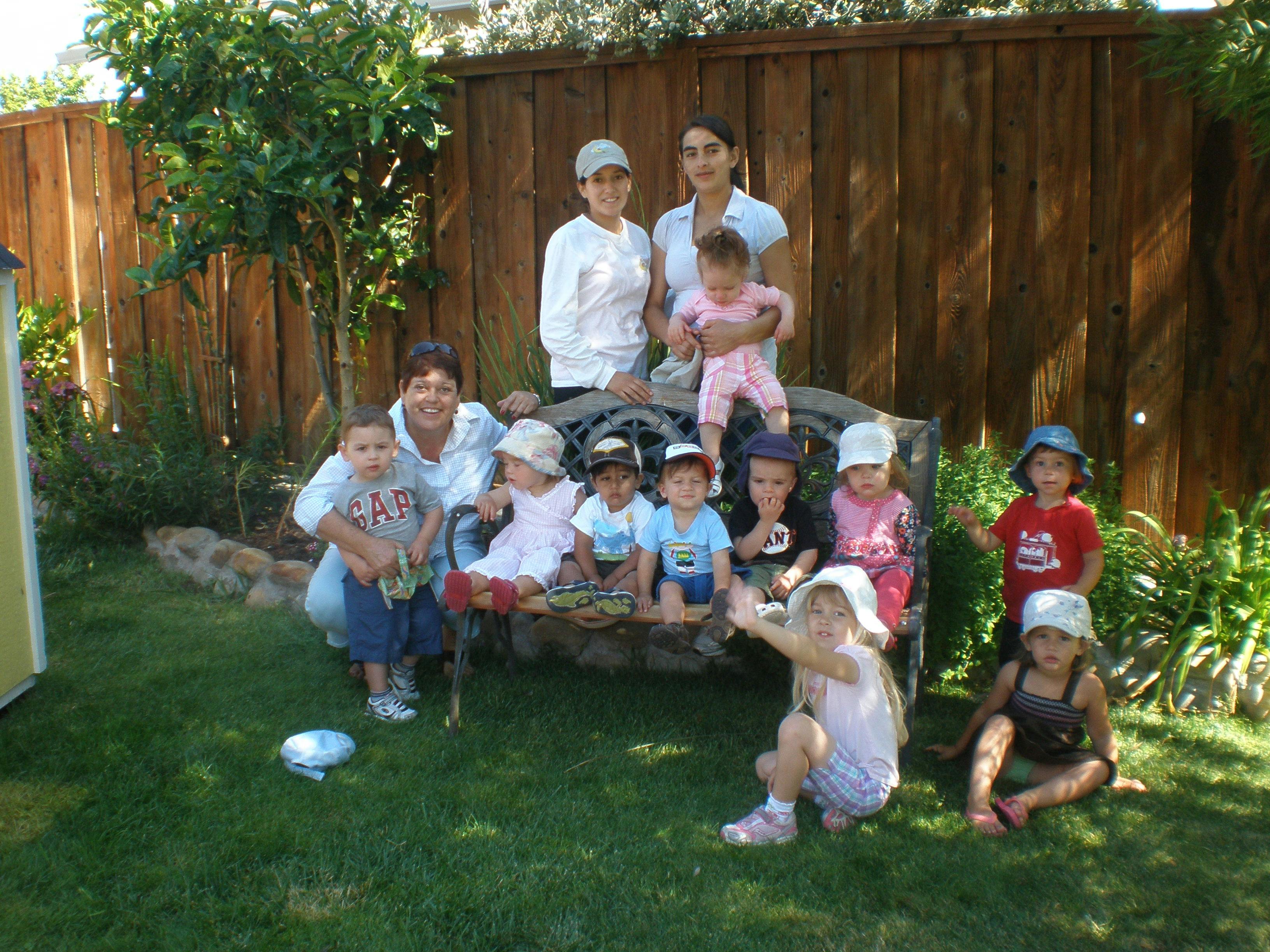 Two people and multiple children posing outdoors