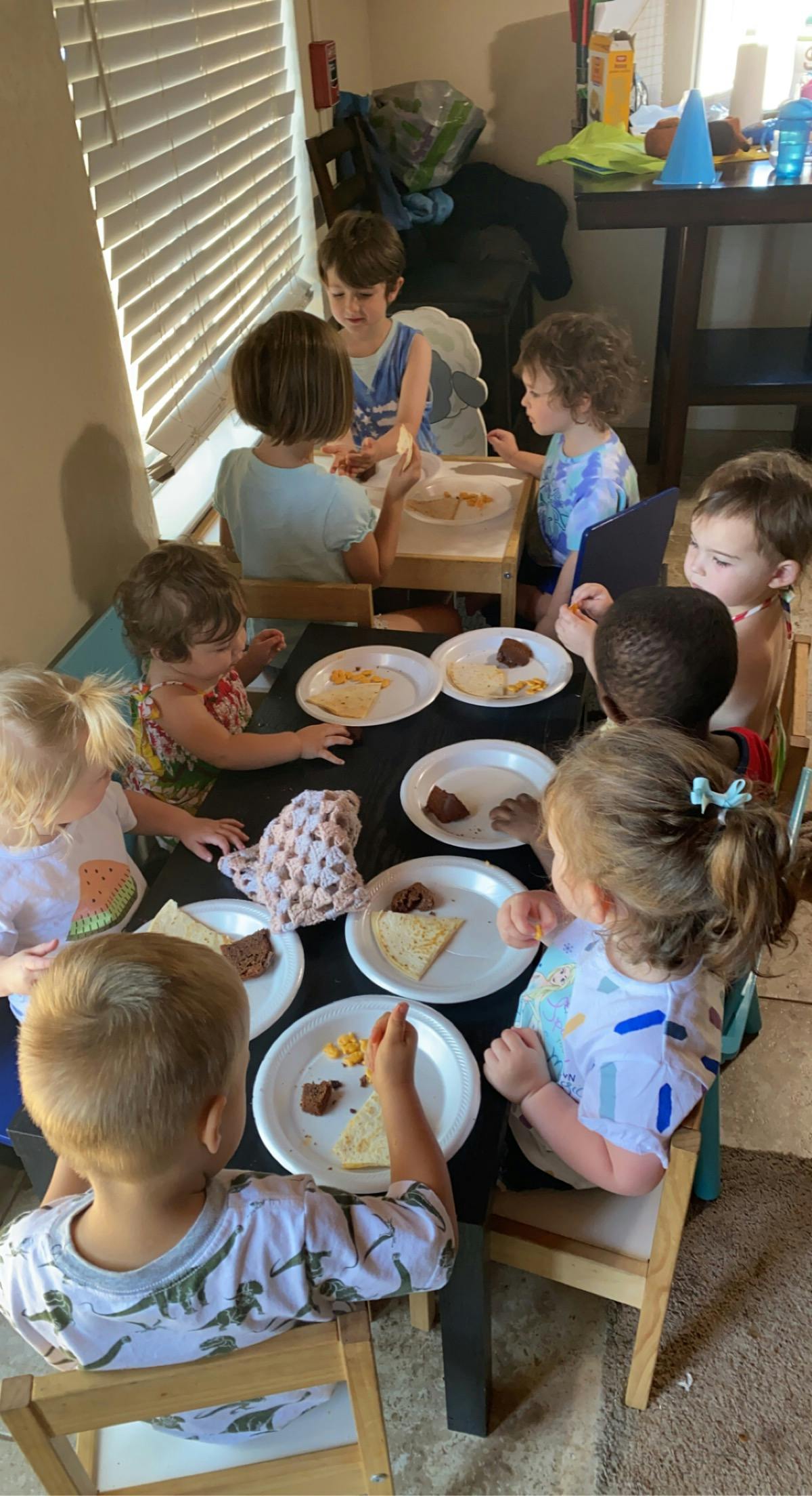 Children sitting around a table with plates of food