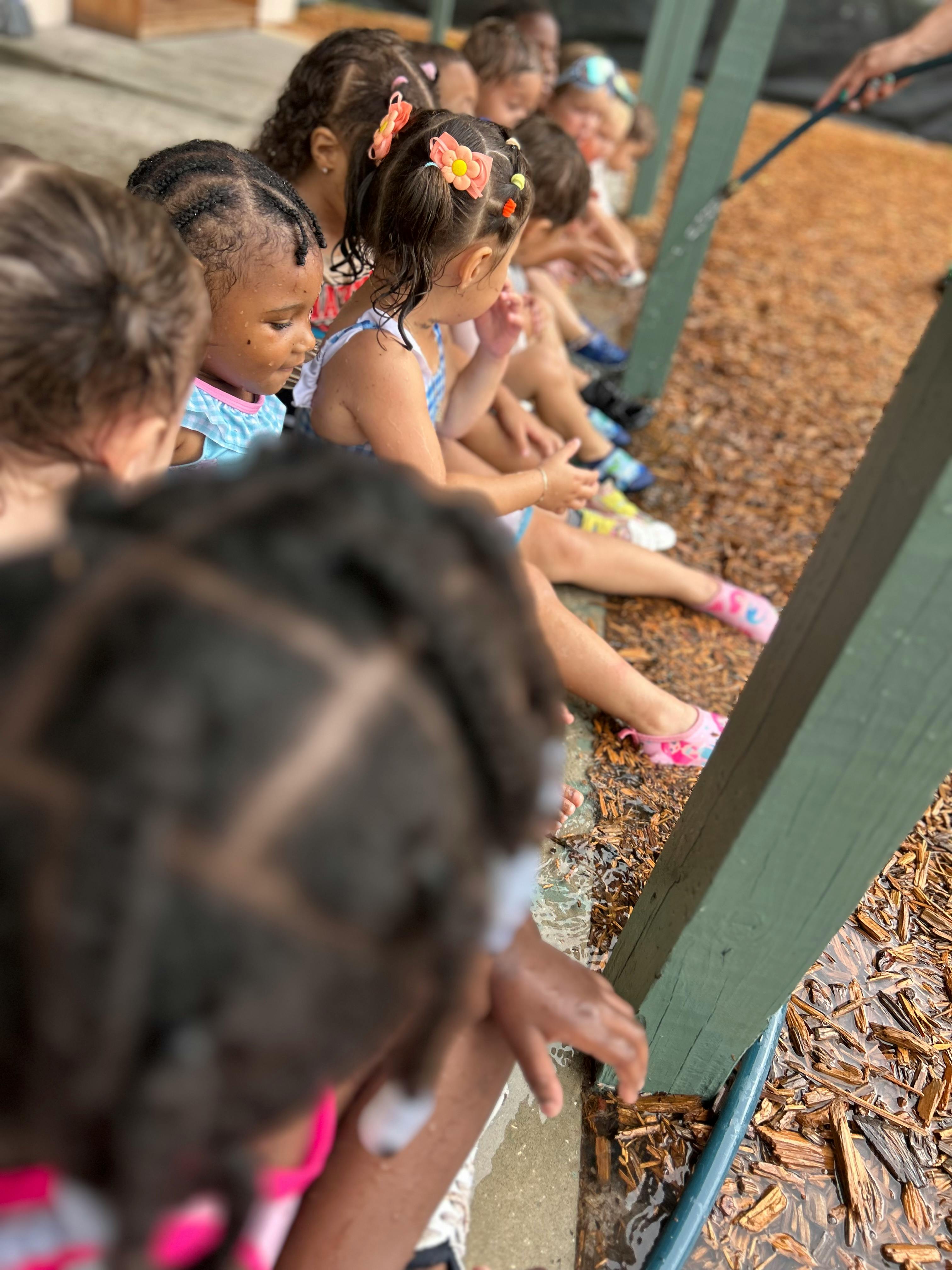 Children sitting and looking down at water