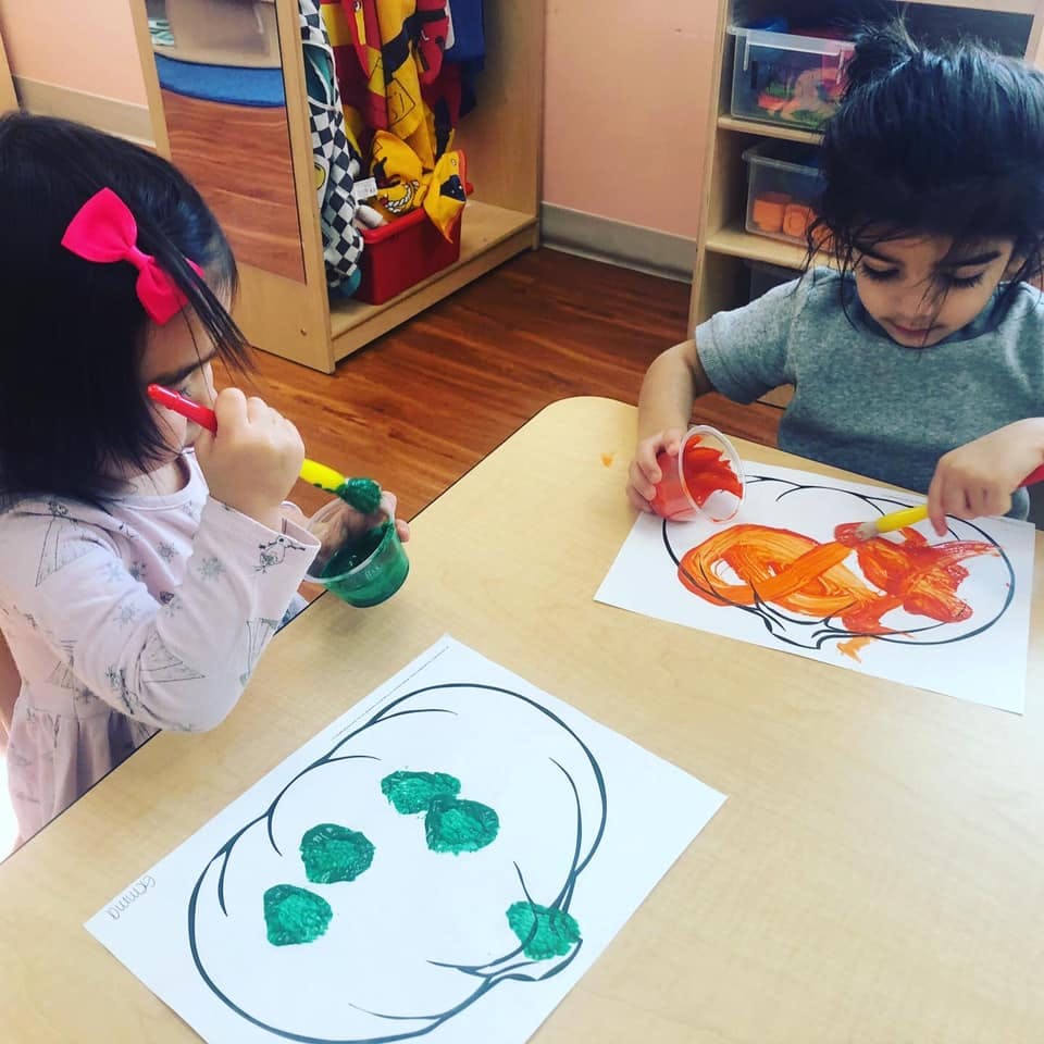Two children painting at a table