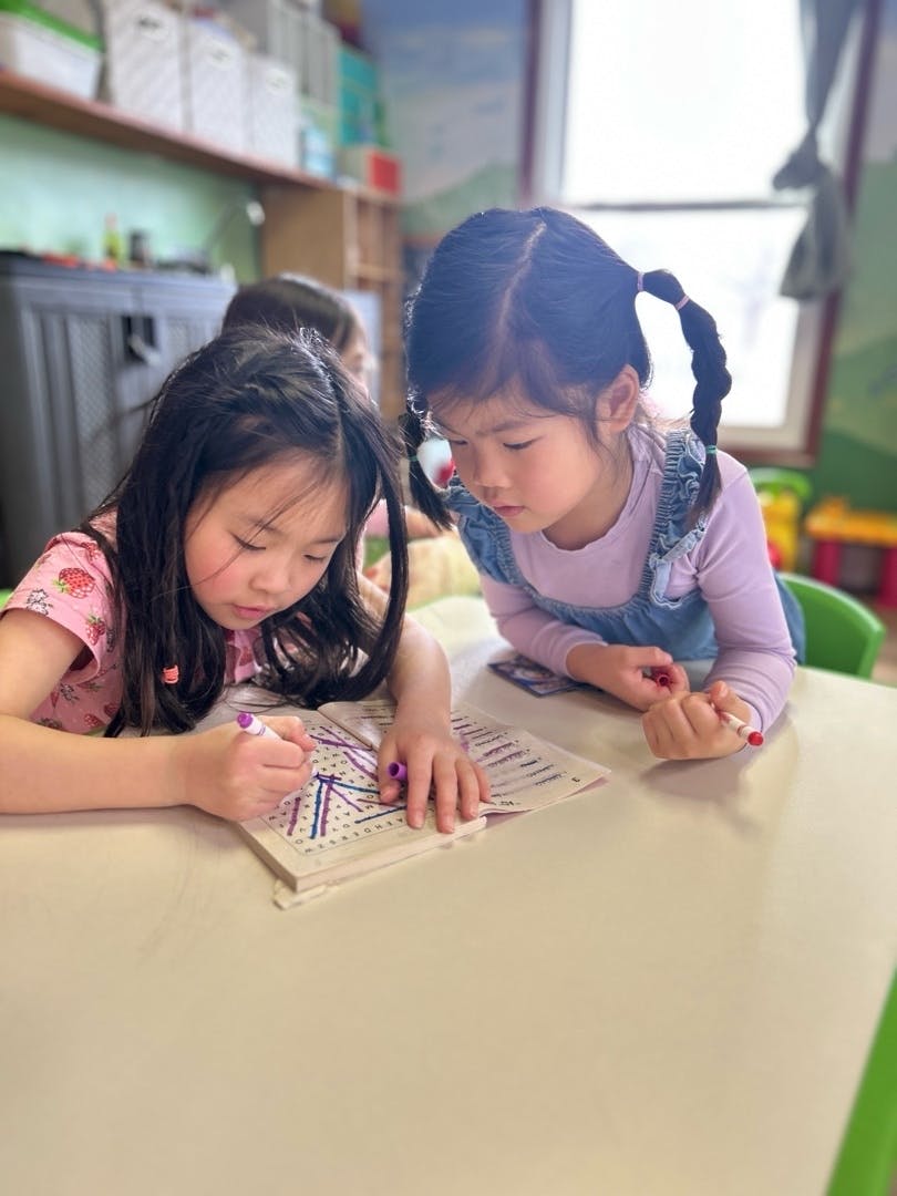 Children working together on a word search puzzle at a table