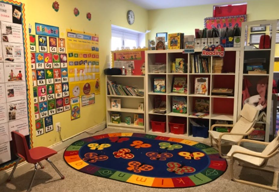 Classroom with alphabet charts, bookshelves, and a colorful rug