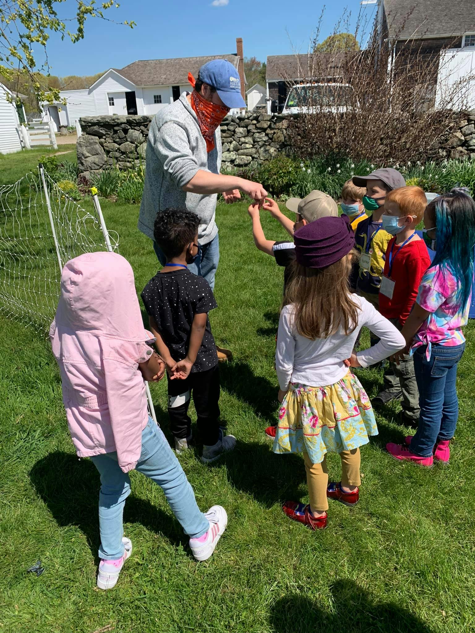Adult person interacting with a group of children outdoors