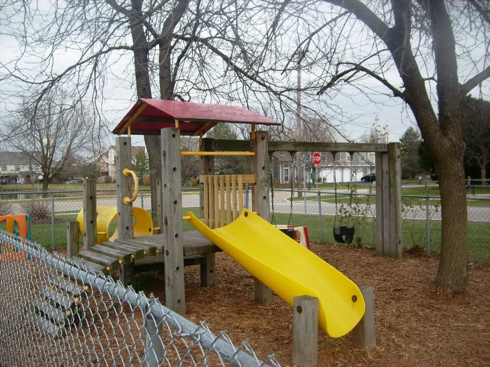 Playground with yellow slide and swings