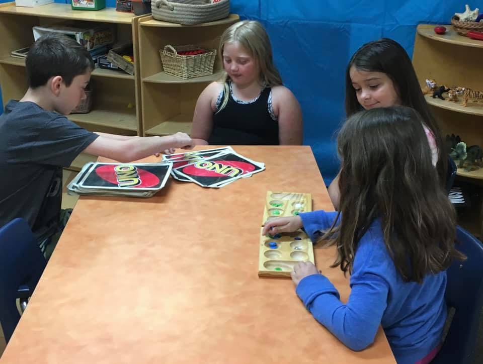 Children playing board games at a table
