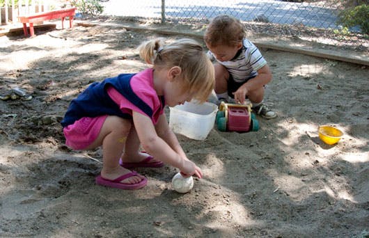 Two children playing in a sandbox