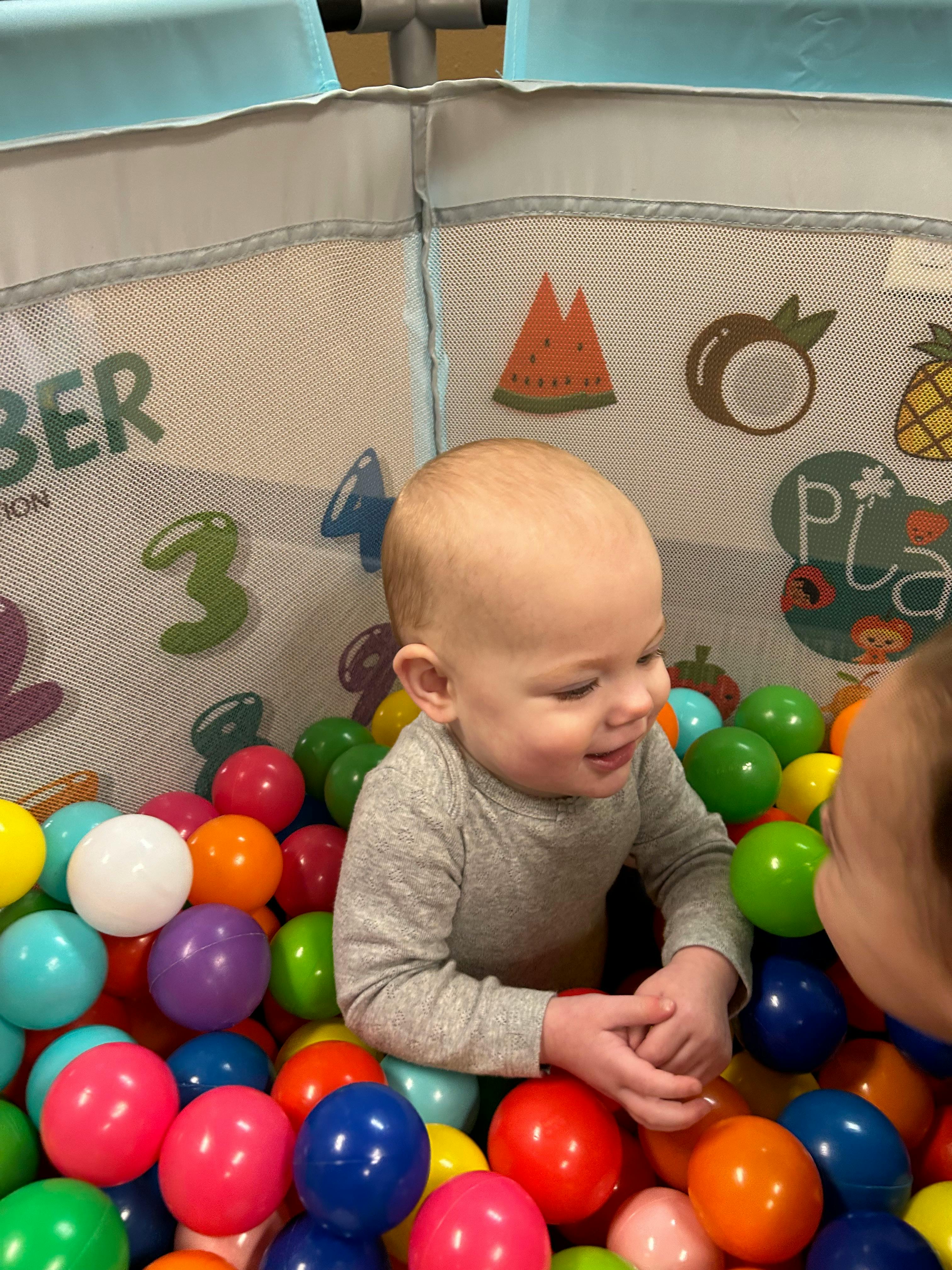Child in a ball pit with another child