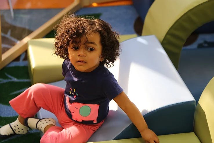 Child sitting on soft play equipment