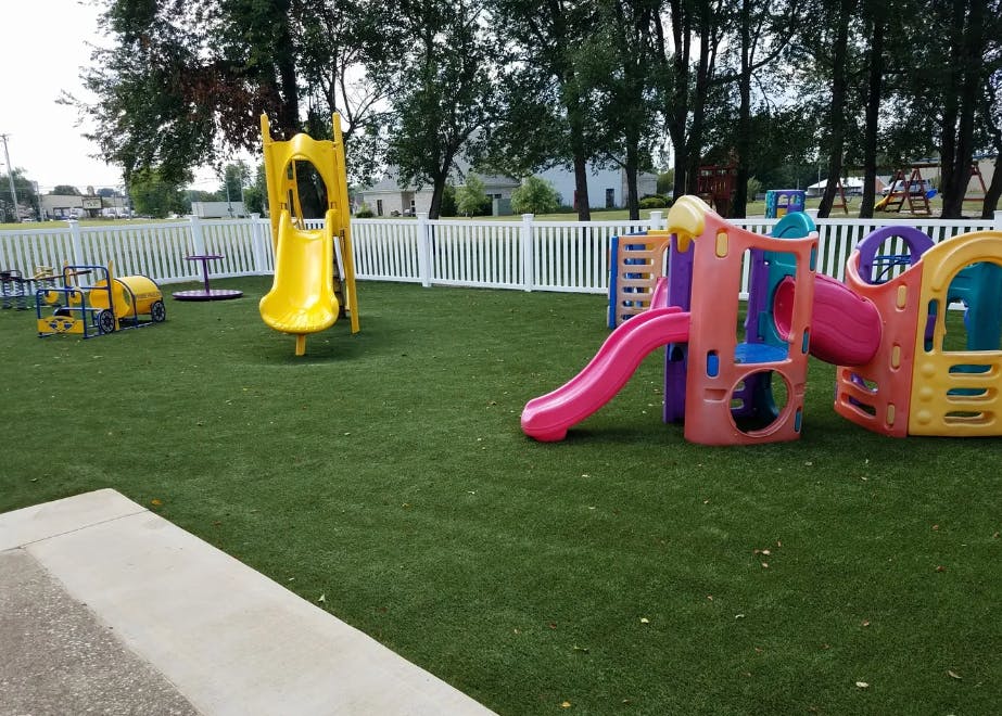Playground with multiple slides and play structures on artificial turf