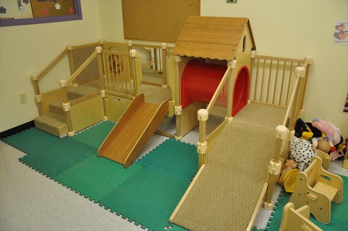Indoor playground with slides, ramps, and a playhouse