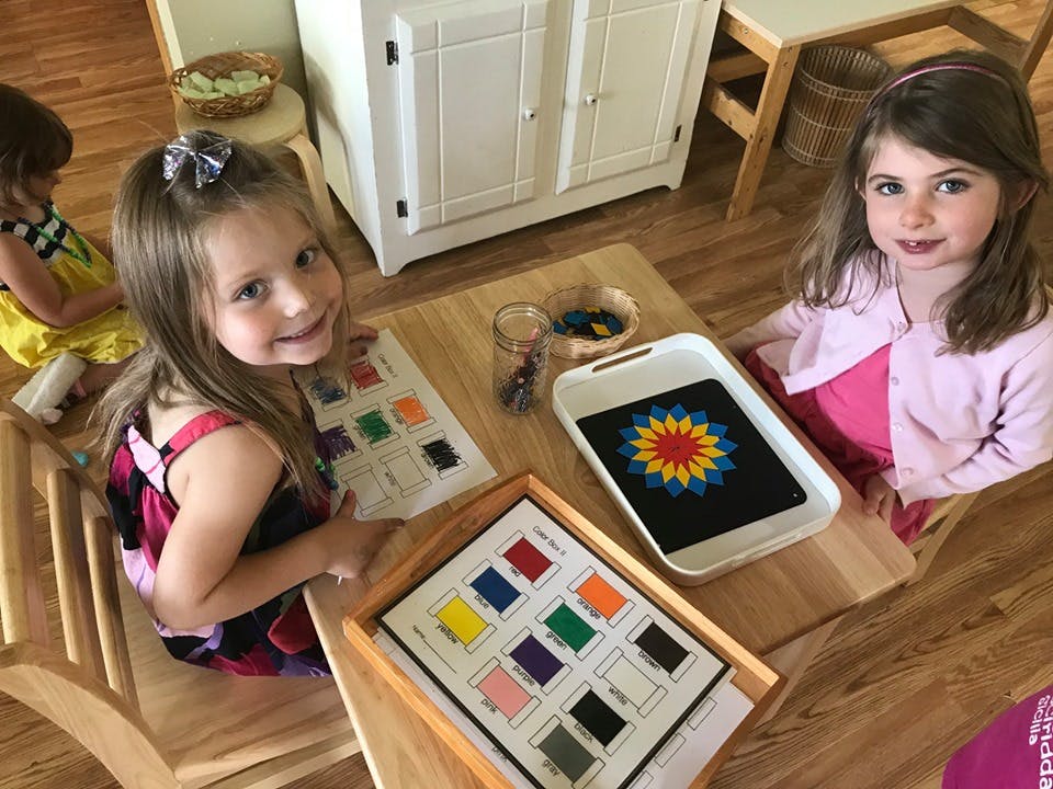 Two children at a table with learning materials
