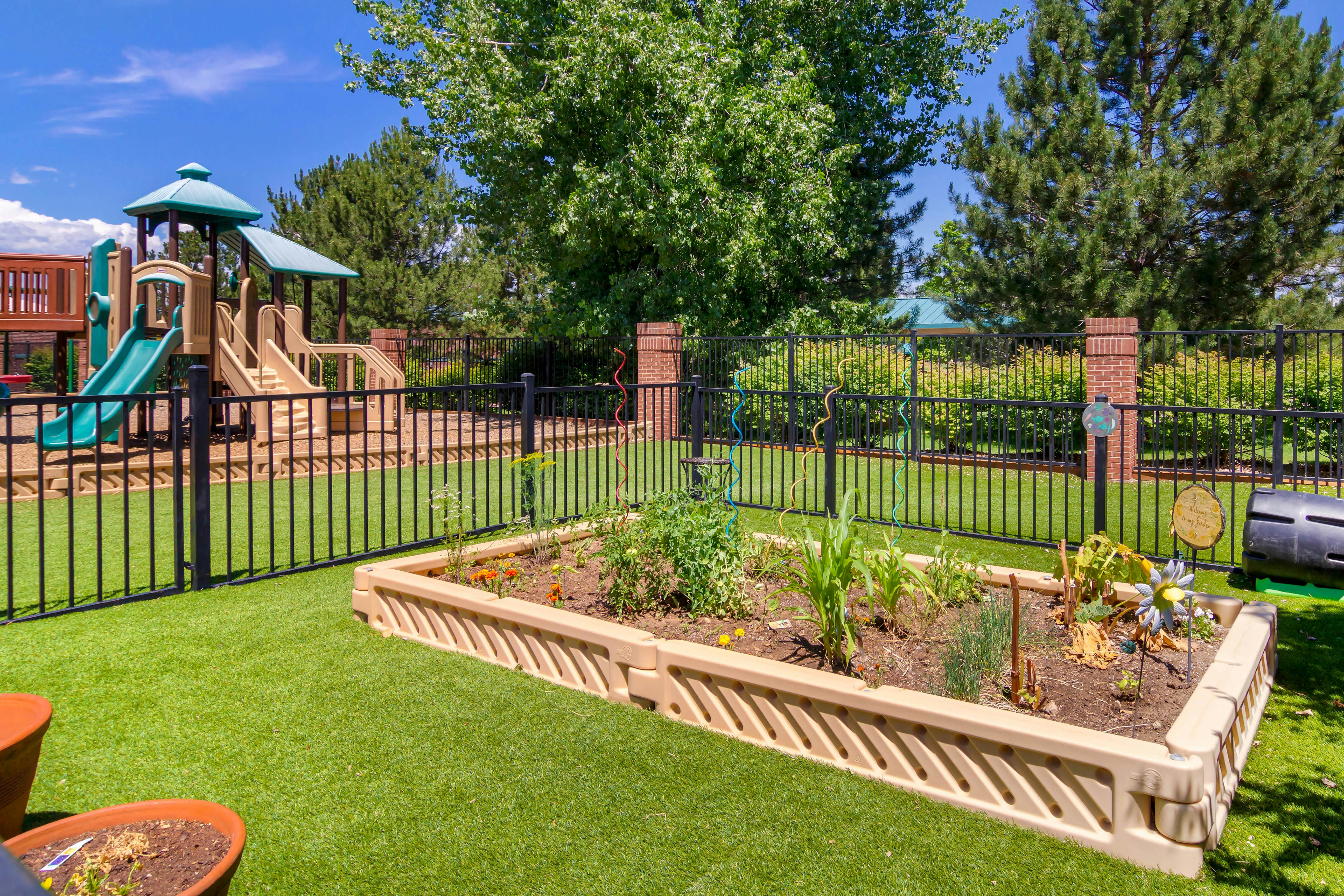 Playground with a raised garden bed and artificial turf