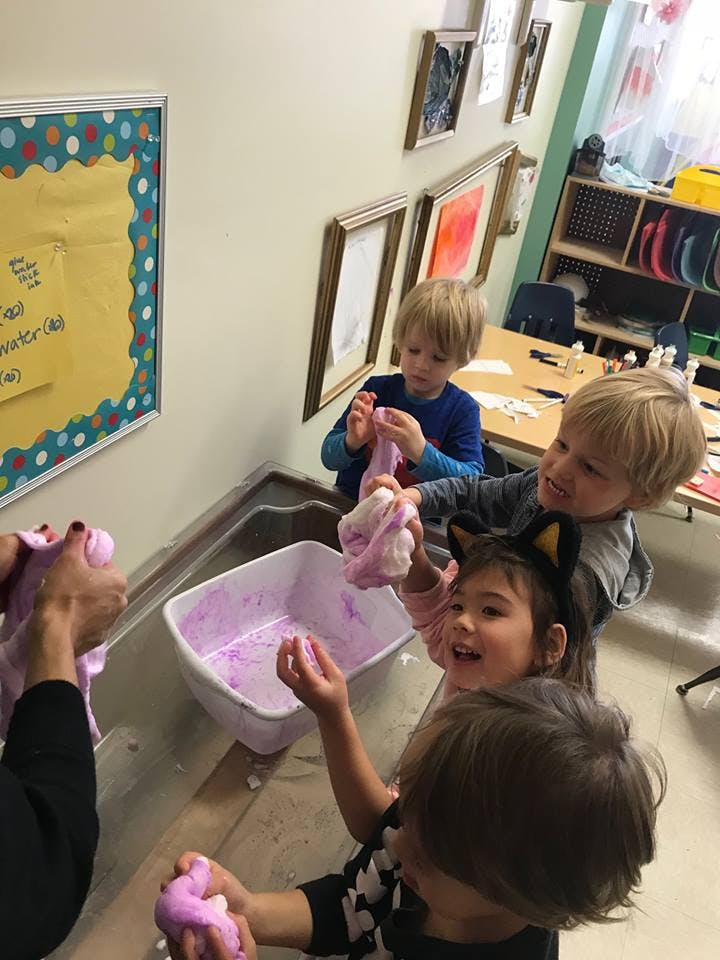 Children playing with purple slime in a classroom
