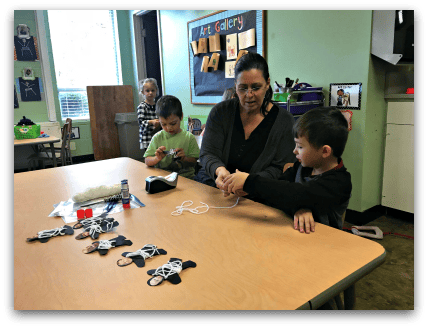 Adult and child working on a craft project at a table