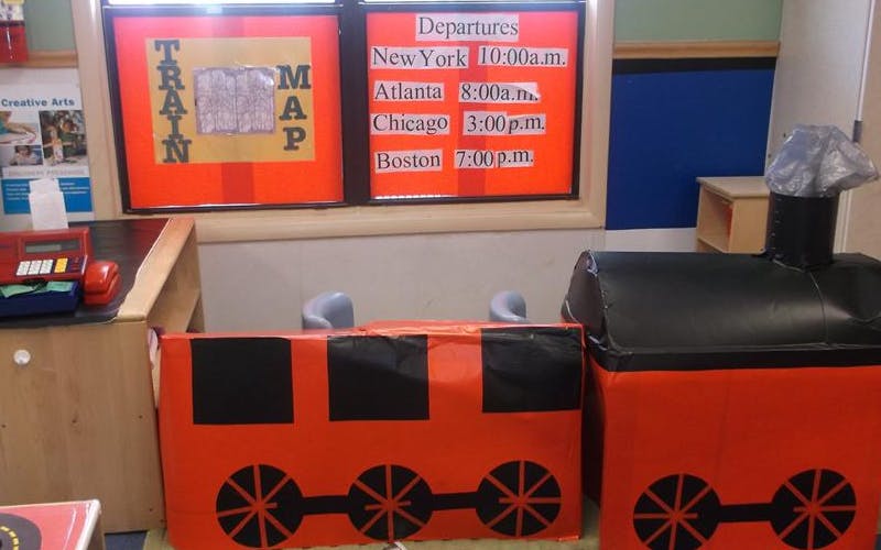 Playroom with a toy train, train map, and departures schedule