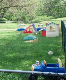 Outdoor playground with a slide, playhouse, and sandbox