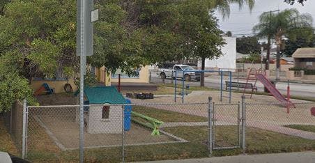 Playground with a small playhouse, slide, and climbing structure