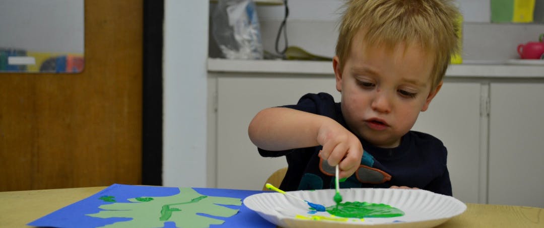 Child painting on a paper plate