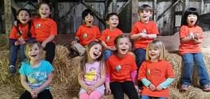 Group of children sitting on hay bales