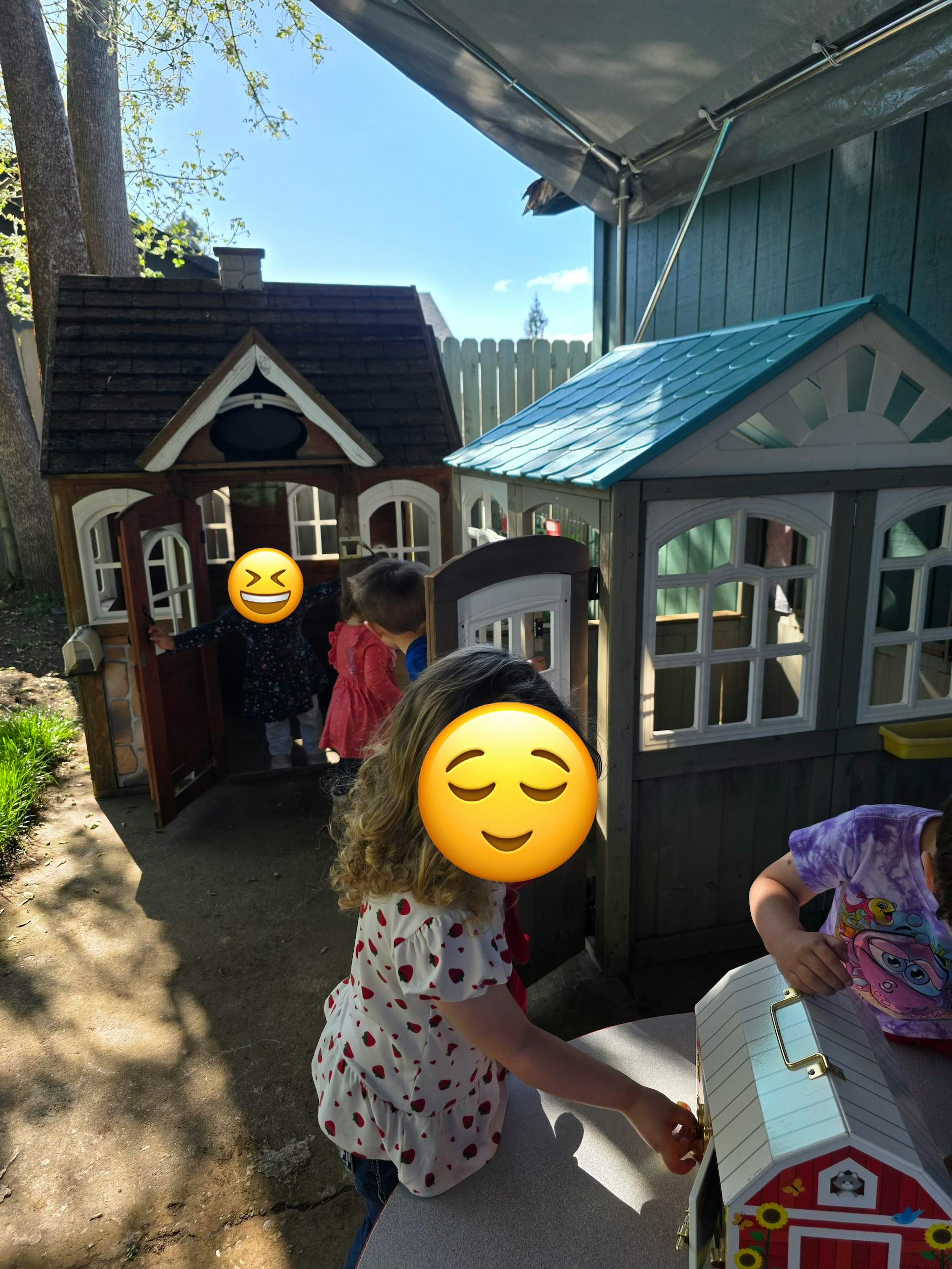 Children playing with toy houses outdoors