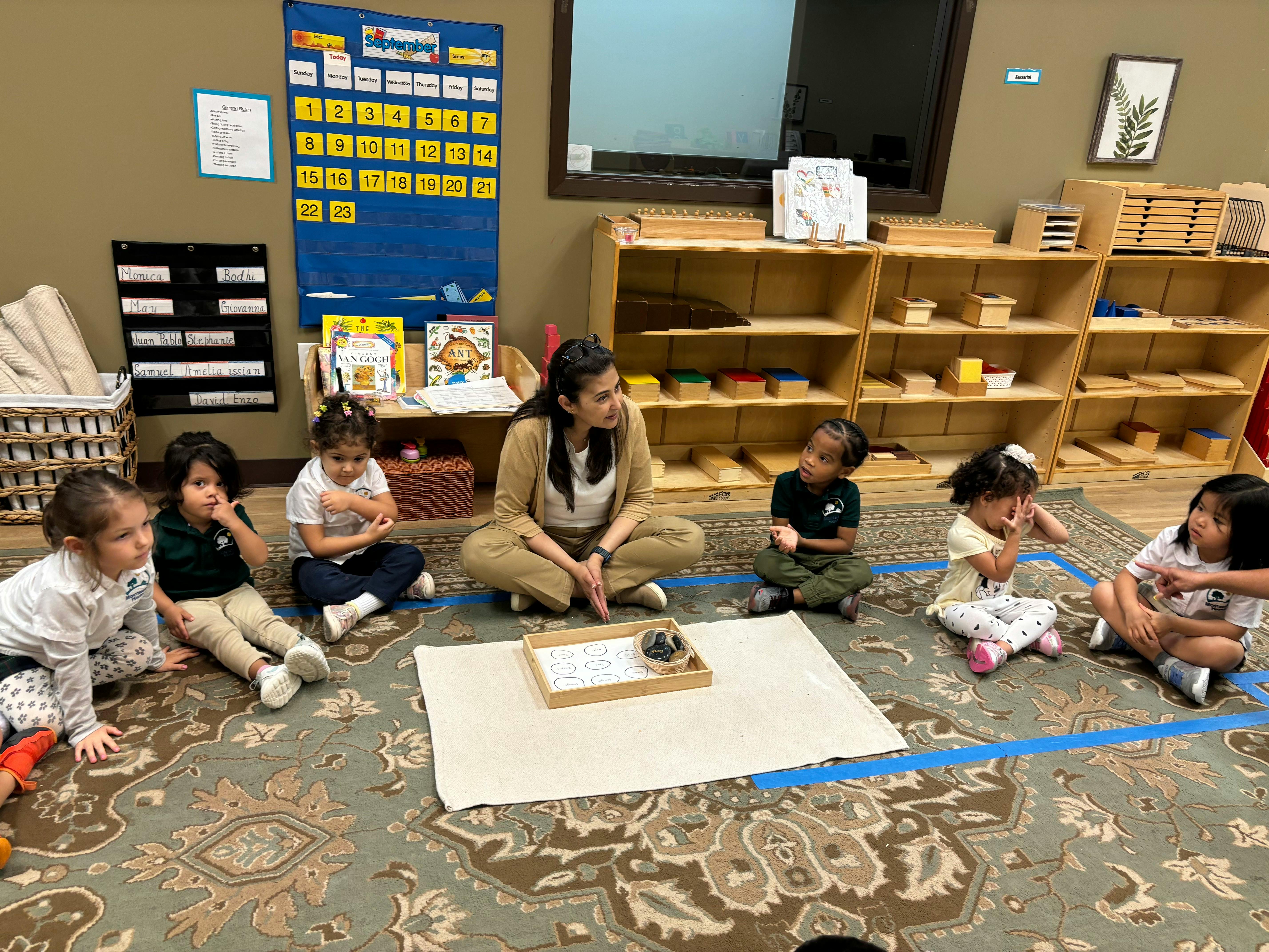 Adult and children sitting on a rug in a classroom