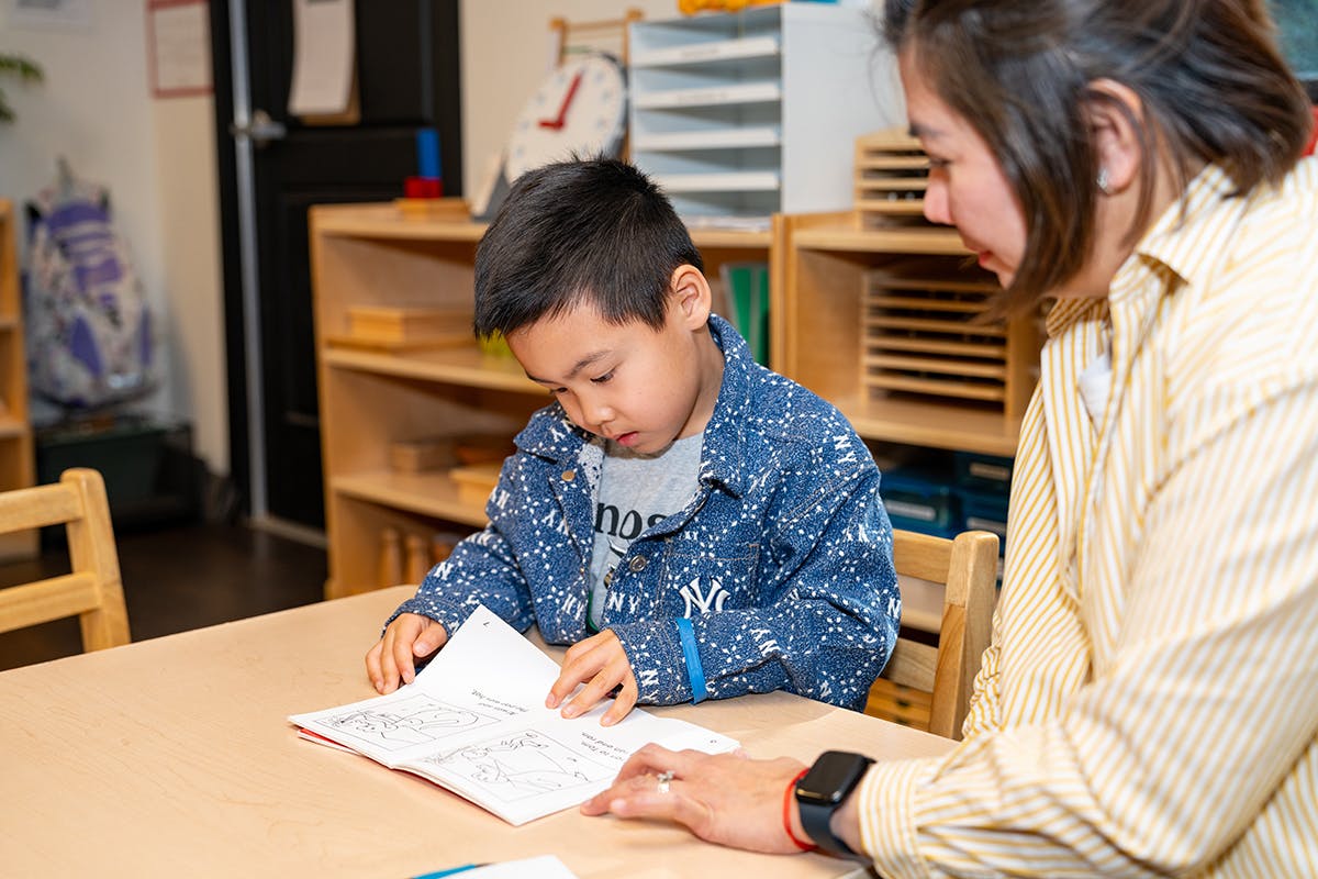 Adult and child looking at papers on a table
