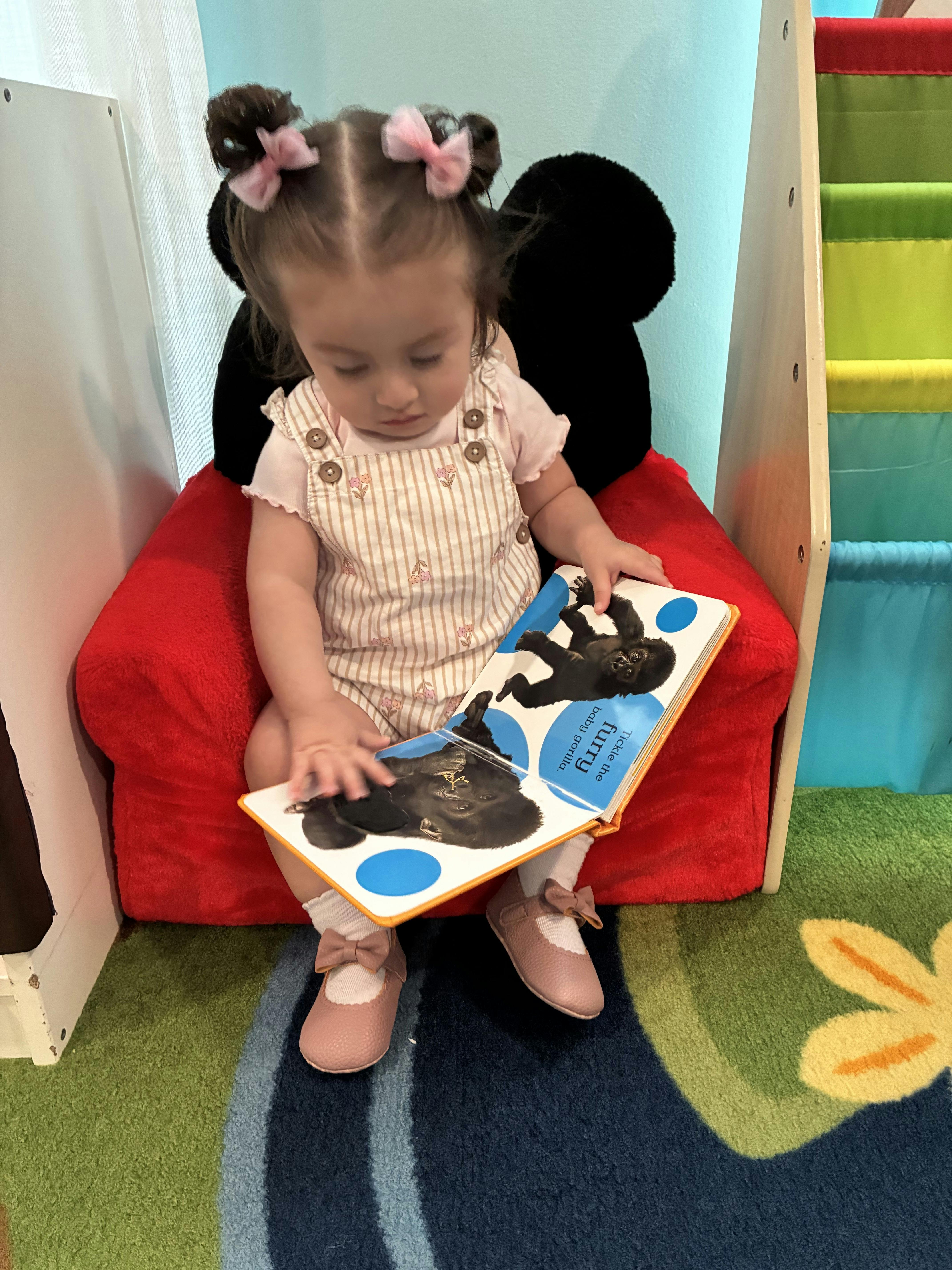 Child sitting in a chair reading a book