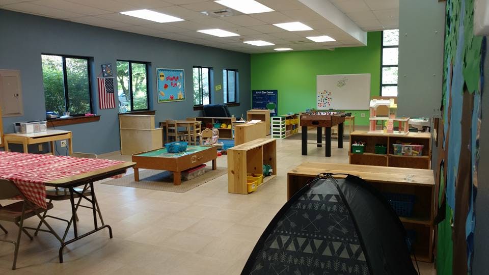 Classroom with tables, shelves, and a foosball table