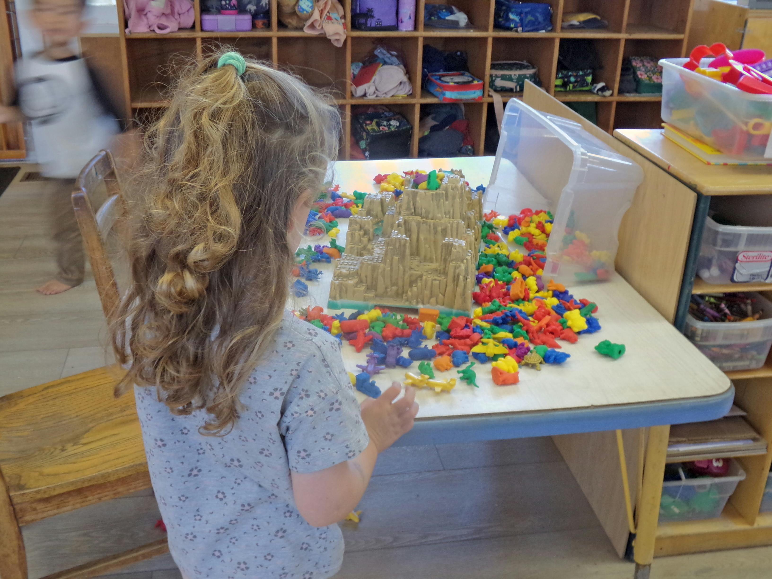 Child playing with colorful building blocks on a table