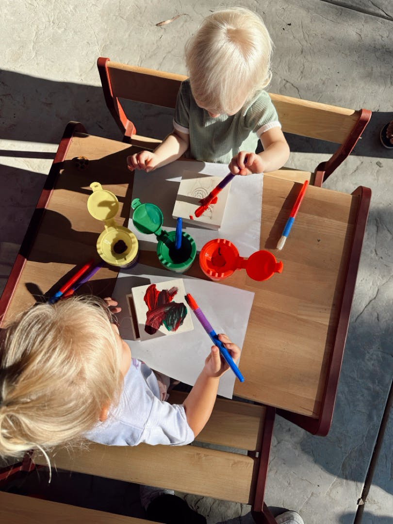 Two children painting at a table