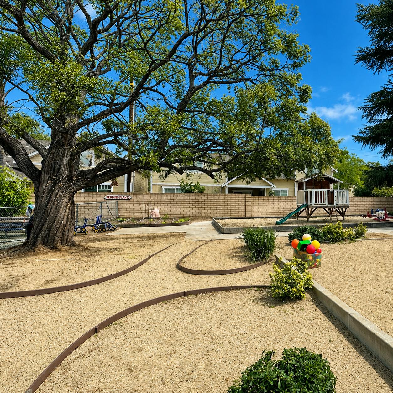 Playground with a large tree and a small playhouse