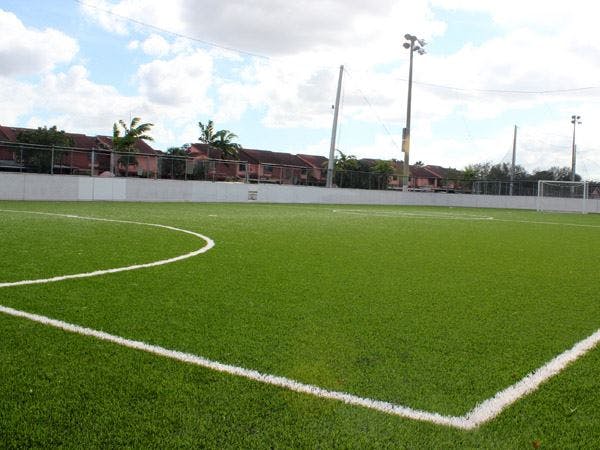 Empty green sports field with white lines and a goal