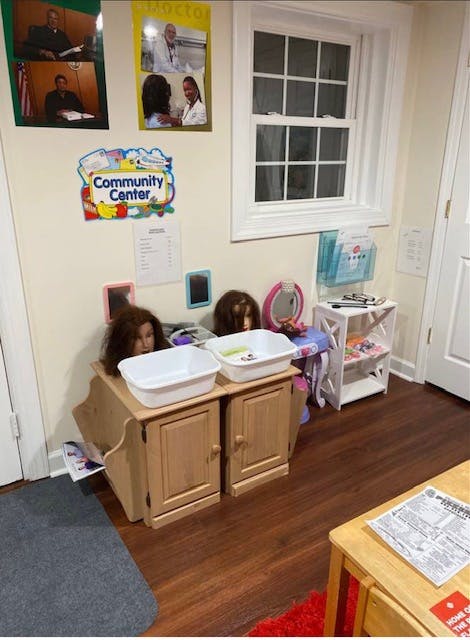 Room with a window, a "Community Center" sign, and two wig heads on cabinets