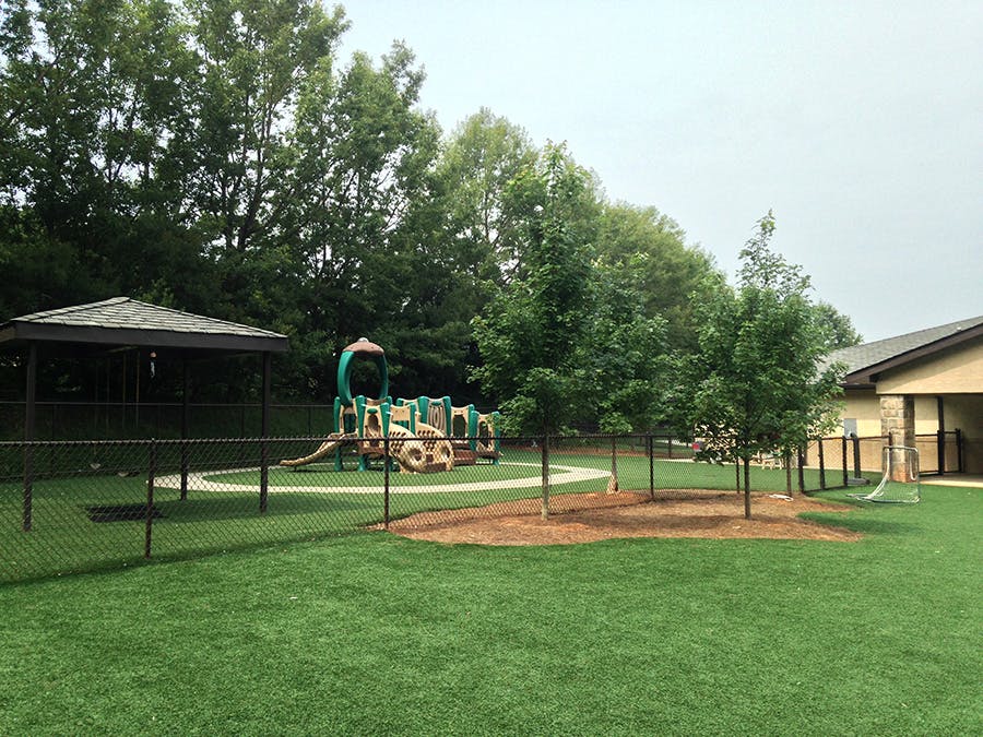 Outdoor playground with a gazebo and play structure on artificial turf