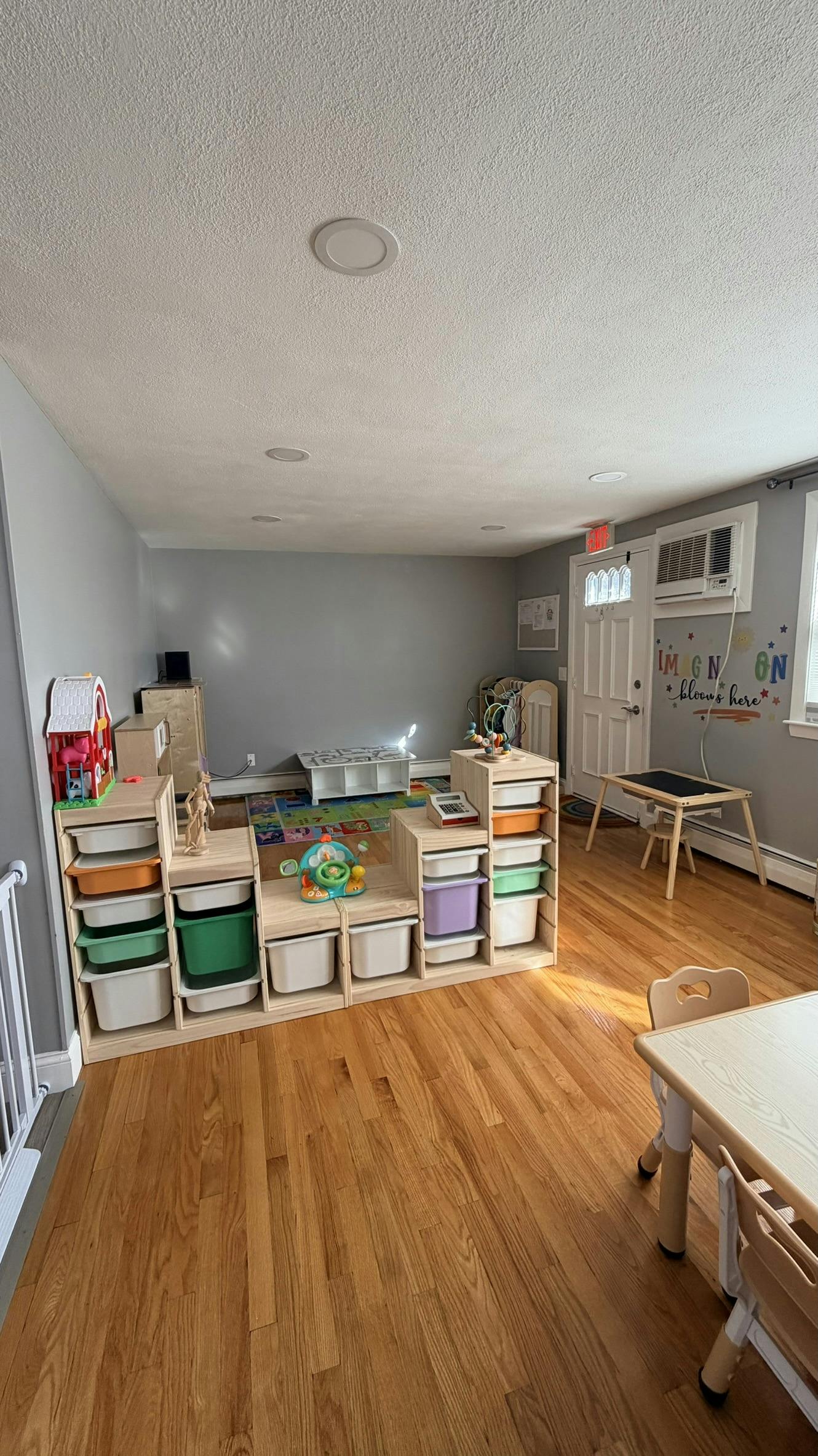 Child's play area with storage bins, toys, small tables, and chairs