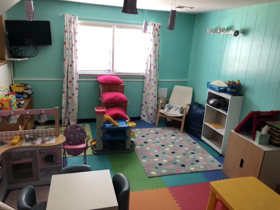 Playroom with colorful floor mats, toys, and furniture