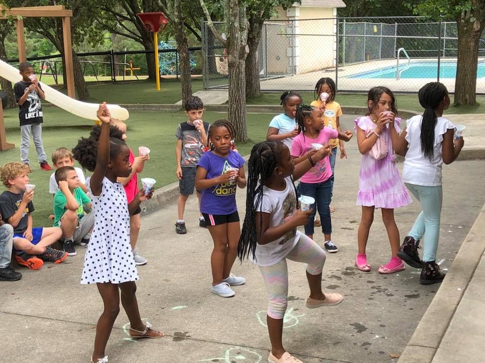 Group of children playing outdoors with cups