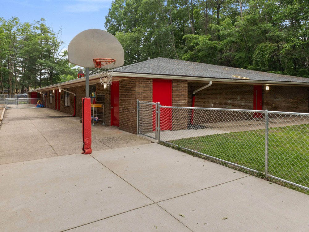 Basketball hoop on a paved area next to a brick building