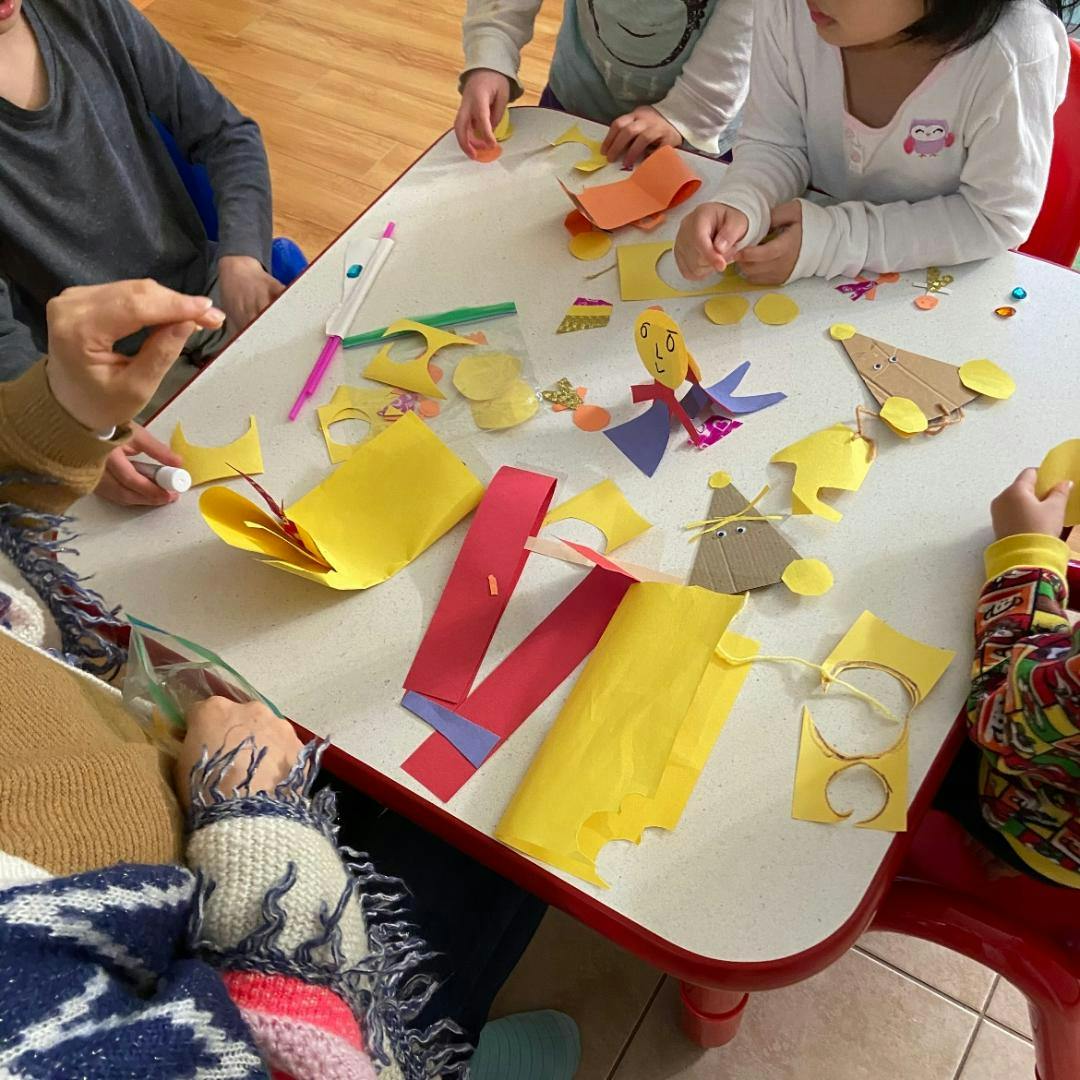 People and children making crafts at a table