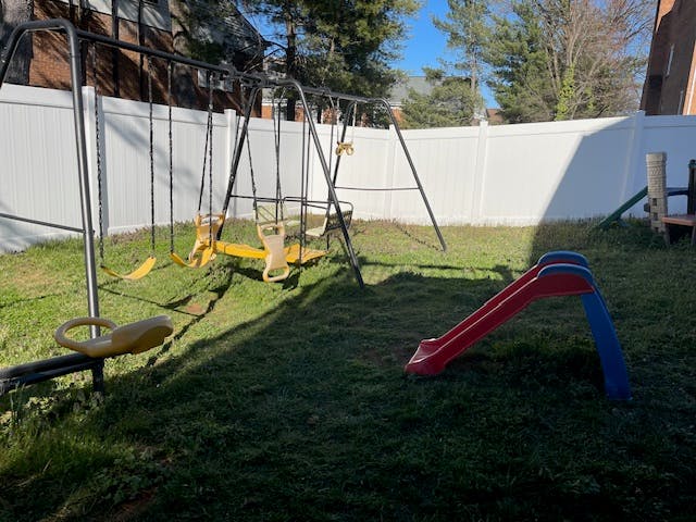 Swing set and slide in a grassy backyard