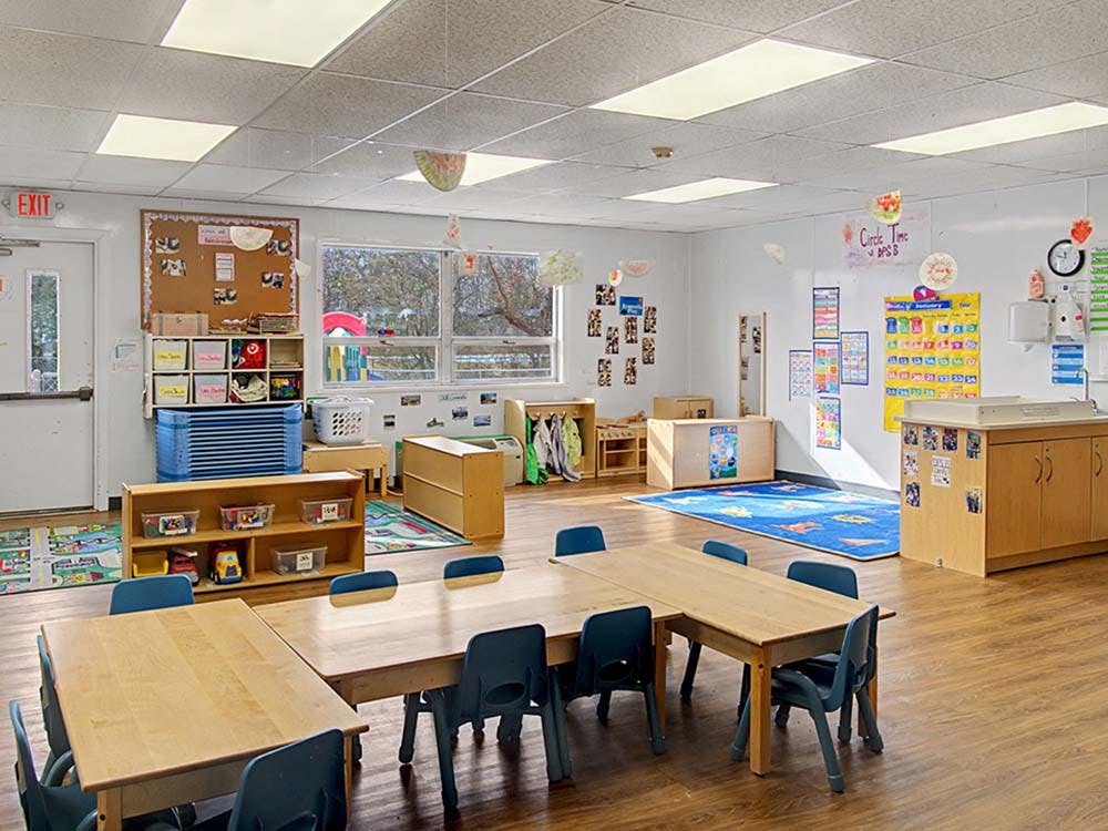 Empty colorful children's classroom with tables and chairs