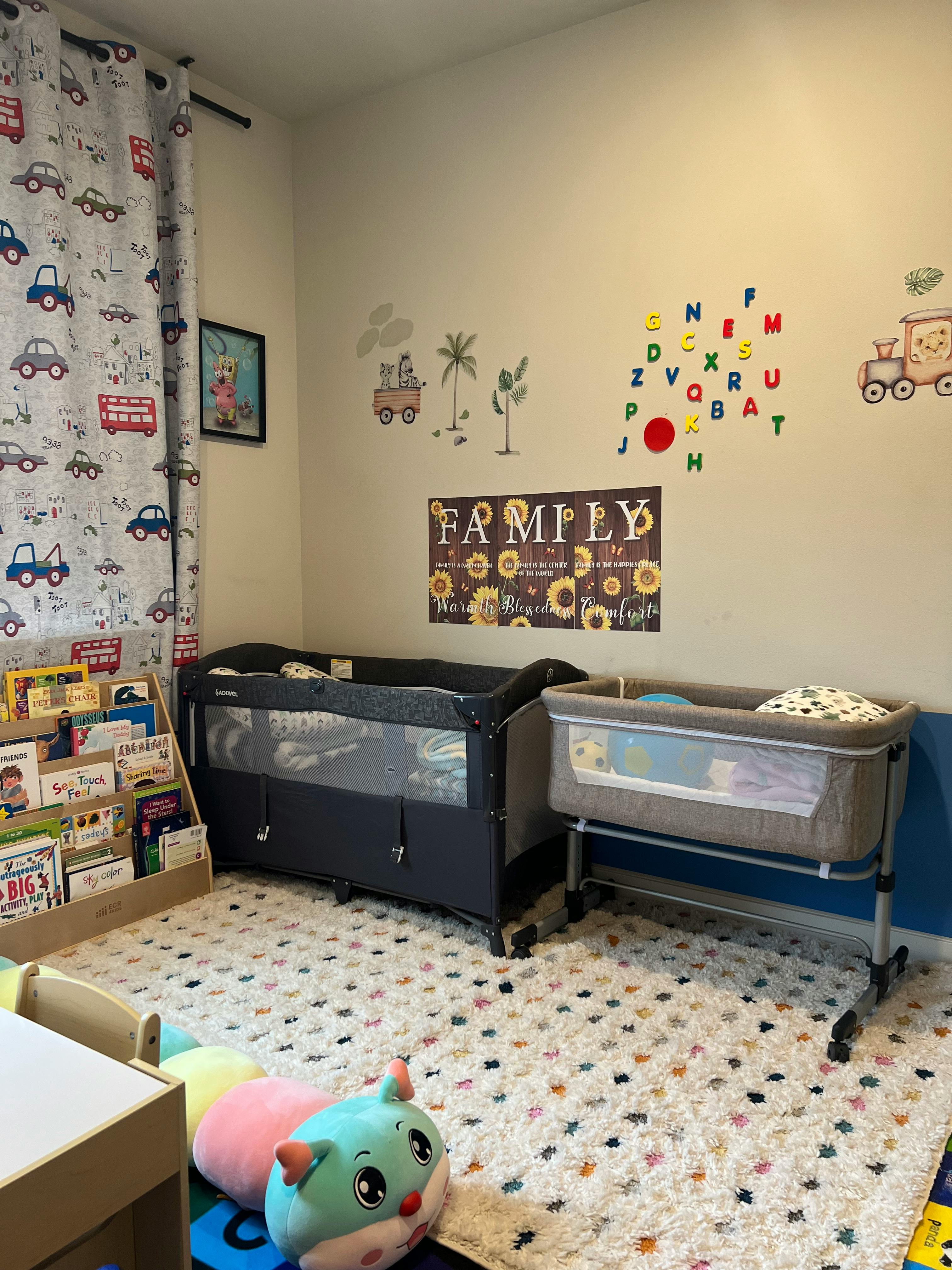 Two cribs in a child's room with a bookshelf and toys